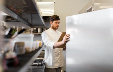 chef with clipboard doing inventory at kitchen